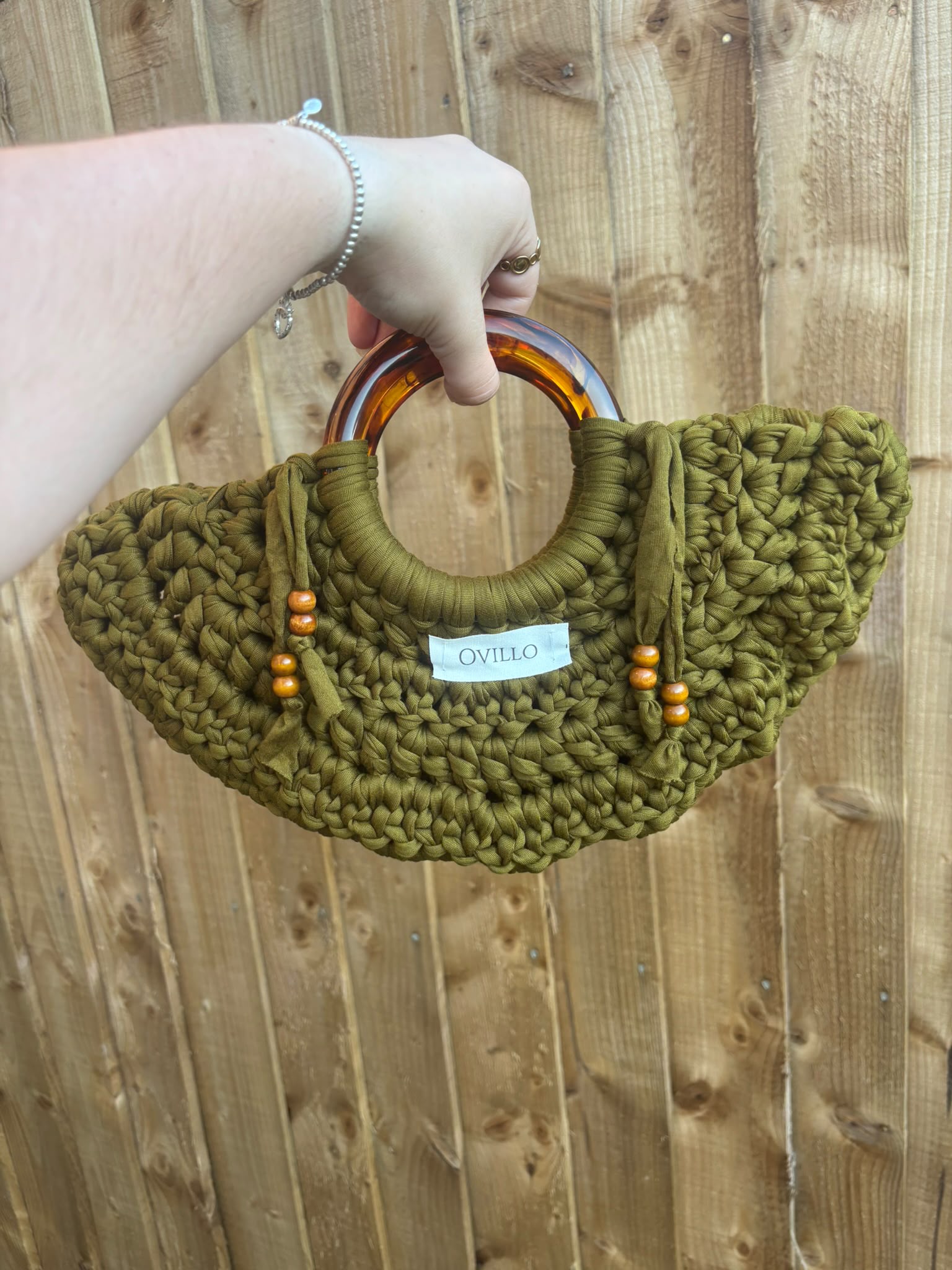 Olive green hand-crocheted bag with curved handles