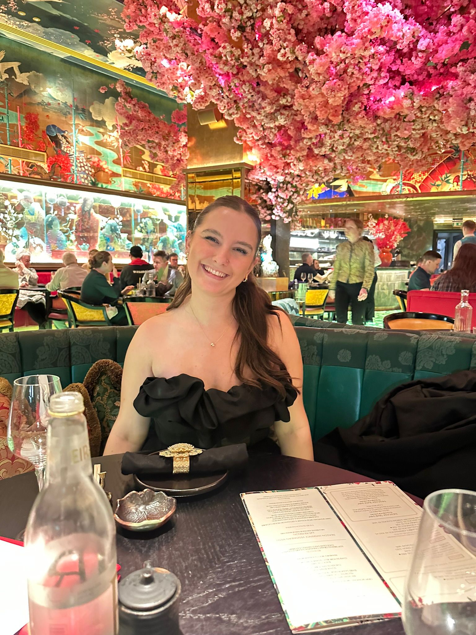 The maker behind Ovillo smiling in a flower-filled restaurant